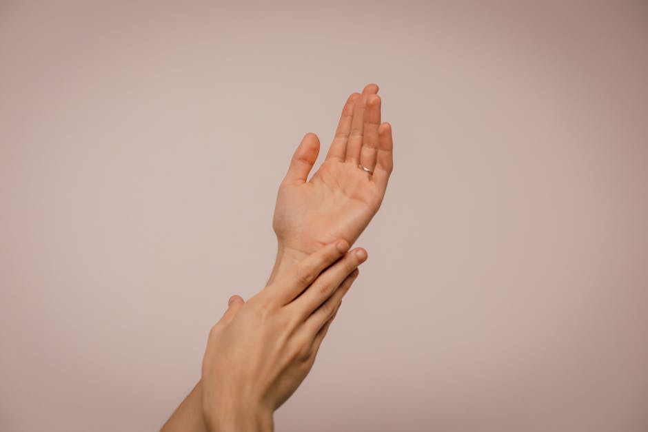 Close-up of hands gently caressing each other, symbolizing self-care and softness